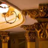 ...i raffinati capitelli dorati delle colonne opera del beneventano Ernesto Giaquinto e i sinuosi bracci delle lampade